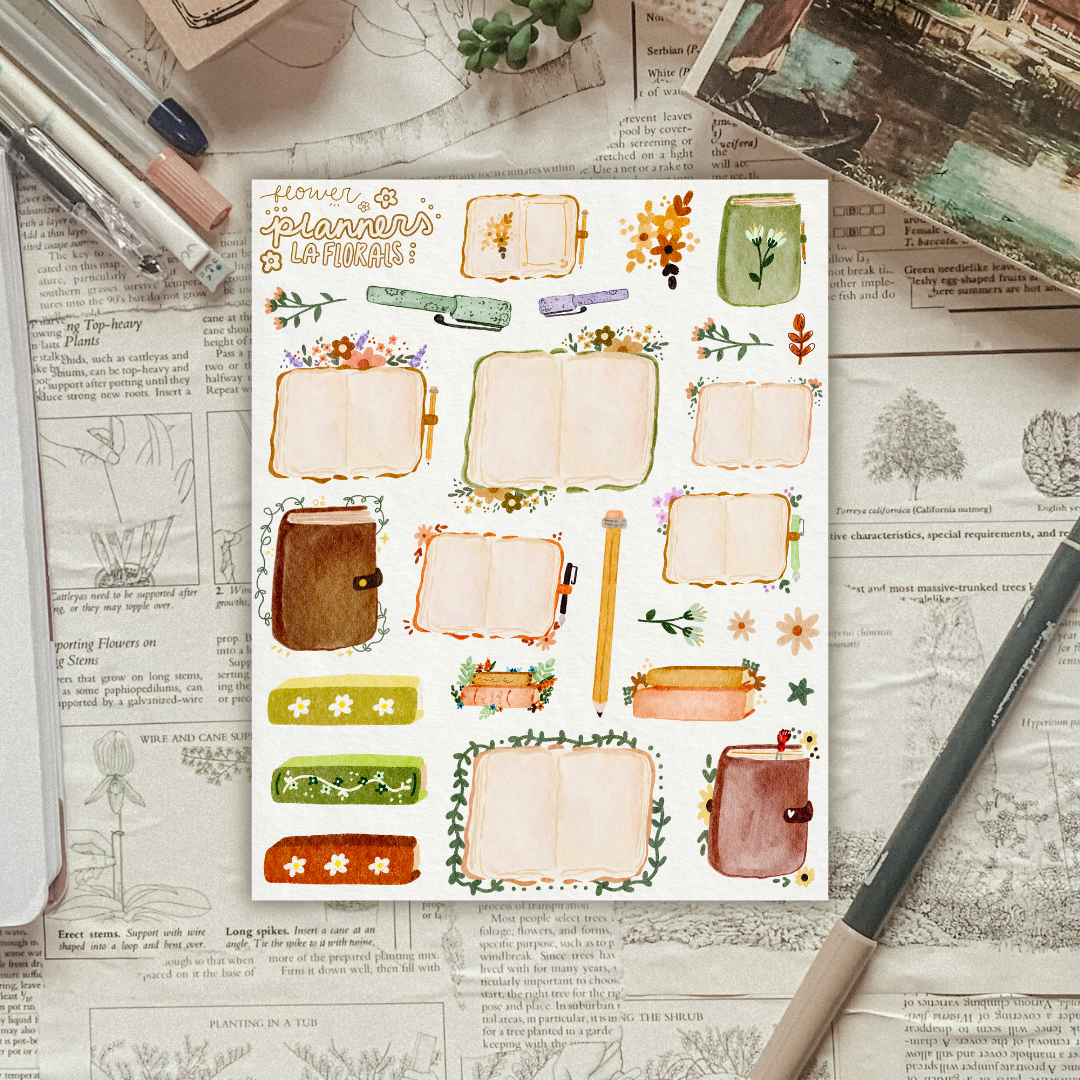 Textured background with a sticker sheet of flowers and open planners laying on top. 
