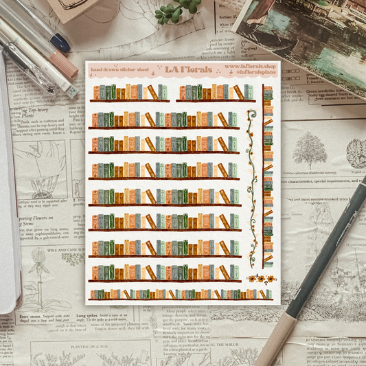 Sheet of decorative stickers with bookshelf design on a textured surface with stationery items.