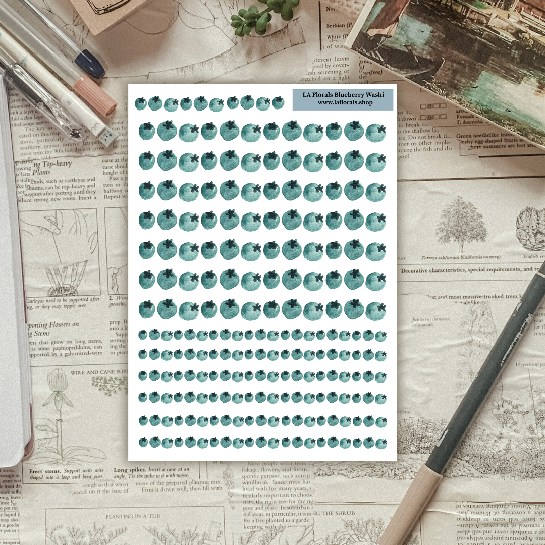 Textured background with a sticker sheet of blueberries laying on top. 